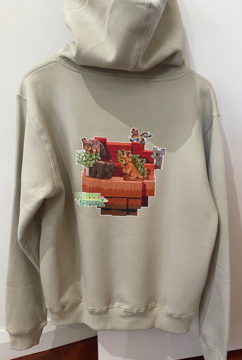 A cosy unisex hoodie featuring Square Safari’s Kimberley Aussie Animals design, created from scratch by Jessica, by hand and without AI.

The midweight brushed fleece combines everyday softness with warmth for cooler days.

The details:

320 GSM poly-blend fleece
Brushed inner lining for softness and warmth
Classic kangaroo pocket
Adjustable drawstrings with easy-to-remove toggles